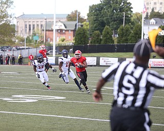 Youngstown State University tail back Tevin McCaster (37) evades Robert Morris University defensive back Heavon Price (25) and Robert Morris University defensive back Ryan Richards Jr. (21) as Side Judge Dorran Stewart throws his flag in the third quarter as Robert Morris University takes on Youngstown State University, Saturday, Sept. 9, 2017, at Stambaugh Stadium in Youngstown. Youngstown State won 30-0...(Nikos Frazier | The Vindicator)..