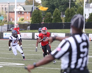 Youngstown State University tail back Tevin McCaster (37) evades Robert Morris University defensive back Heavon Price (25) and Robert Morris University defensive back Ryan Richards Jr. (21) as Side Judge Dorran Stewart throws his flag in the third quarter as Robert Morris University takes on Youngstown State University, Saturday, Sept. 9, 2017, at Stambaugh Stadium in Youngstown. Youngstown State won 30-0...(Nikos Frazier | The Vindicator)..