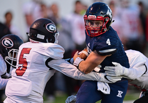 WARREN, OHIO - SEPTEMBER 9, 2017: JFK's Gregory Valent runs the ball while running through arm tackles by Girard's Nick Malito, left, and Cameron LaMonica and into the end zone to score a touchdown during the first half of their game Saturday night at Warren Harding High School. DAVID DERMER | THE VINDICATOR