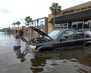 John Duke tries to figure out how to salvage his flooded vehicle in the wake Hurricane Irma, Monday, Sept. 11, 2017, in Jacksonville, Fla. (AP Photo/John Bazemore)
