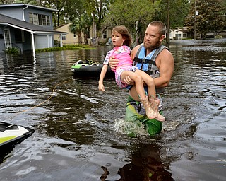 Tommy Nevitt carga a Miranda Abbott de seis aÃ±os a travÃ©s de una inundaciÃ³n provocada por el huracÃ¡n Irma en la parte oeste de la ciudad de Jacksonville, Florida, el lunes 11 de septiembre de 2017. (Dede Smith/The Florida Times-Union vÃ­a AP)