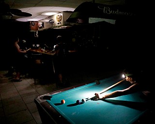 Lisa Borruso plays pool using a headlamp as the power remains out following Hurricane Irma at Gators' Crossroads in Naples, Fla., Monday, Sept. 11, 2017. Statewide, an estimated 13 million people, or two-thirds of Florida's population, remained without power. That's more than the population of New York and Los Angeles combined. Officials warned it could take weeks for electricity to be restored to everyone. (AP Photo/David Goldman)
