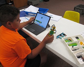 Neighbors | Zack Shively.A child examined and fixed his robot at Lego WeDo Robots in the main library on Aug. 7.