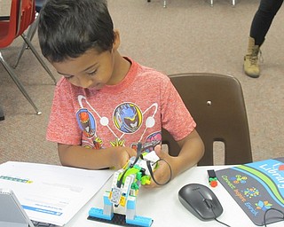 Neighbors | Zack Shively .A child picked up a Lego scrulpture using his robot at Lego WeDo Robots on Aug. 7 at the main library.