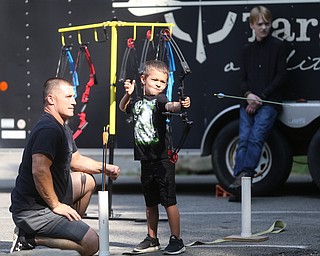 Owen Carothers(6) of Hermitage, Pa. lines up his shot with a bow and arrow with the help of On Target volunteer, Jason Austin during the annual Outdoor Family Fun Day, Saturday, Sept. 16, 2017, at Boardman Park in Boardman...(Nikos Frazier | The Vindicator)..