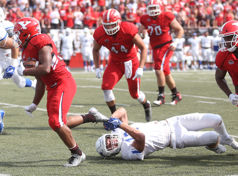 Youngstown State University tail back Tevin McCaster (37) runs as Central Connecticut State University Blue Devils safety Kyle Baum (12) tries to hold onto his shoe in the second quarter as Youngstown State takes on Central Connecticut State, Saturday, Sept. 16, 2017, at Stambaugh Stadium in Youngstown. Youngstown State won 59-9...(Nikos Frazier | The Vindicator)..