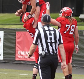 Youngstown State University wide receiver Ricky Davis (12) is lifted into the air by Youngstown State University offensive guard Logan Creek (65) and Youngstown State University offensive tackle Jeff Rotheram (78) after scoring a touchdown in the third quarter as Youngstown State takes on Central Connecticut State, Saturday, Sept. 16, 2017, at Stambaugh Stadium in Youngstown. Youngstown State won 59-9...(Nikos Frazier | The Vindicator)..