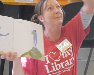 Neighbors | Zack Shively  .Librarian Allison Graf read the story "Hop Jump" to the children at Austintown library during the Gotta Move Story Time event on Aug. 17. The event gives the children a workout while learning literacy, listening and counting skills.