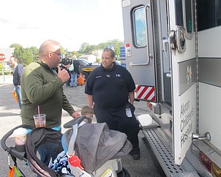 Neighbors | Zack Shively  .The mobile intensive care unit and police talked to families about their jobs. Both displayed their vehicles, with the police often putting on their sirens for the children. Pictured are Frank Zayas (front) and Deputy Randall Pegg (deep background).