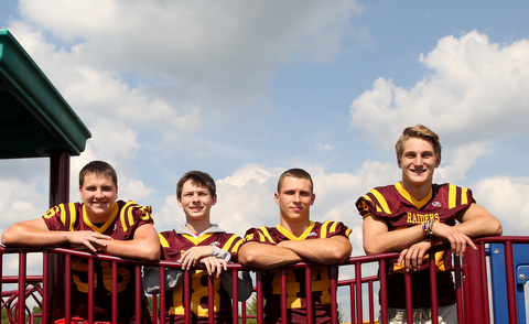 (from left) South Range offensive lineman Matt Brooks (56), South Range wide receiver Mathias Combs (18), South Range running back Peyton Remish (44) and South Range quarterback Aniello Buzzacco (14) pose for a portrait, Tuesday, Sept. 19, 2017, on a school playground at South Range High School in Canfield. ..(Nikos Frazier | The Vindicator)
