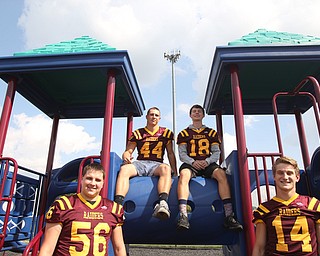 (from left) South Range offensive lineman Matt Brooks (56), South Range running back Peyton Remish (44), South Range wide receiver Mathias Combs (18) and South Range quarterback Aniello Buzzacco (14) pose for a portrait, Tuesday, Sept. 19, 2017, on a school playground at South Range High School in Canfield. ..(Nikos Frazier | The Vindicator)