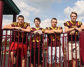 (from left) South Range offensive lineman Matt Brooks (56), South Range wide receiver Mathias Combs (18), South Range running back Peyton Remish (44) and South Range quarterback Aniello Buzzacco (14) pose for a portrait, Tuesday, Sept. 19, 2017, on a school playground at South Range High School in Canfield. ..(Nikos Frazier | The Vindicator)