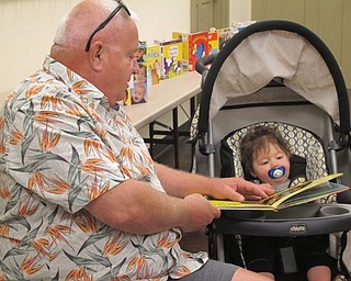 Neighbors | Zack Shively.A man holds a book open for a baby to look at on Aug. 8 at the Boardman library's Bonding with Babies and Books.