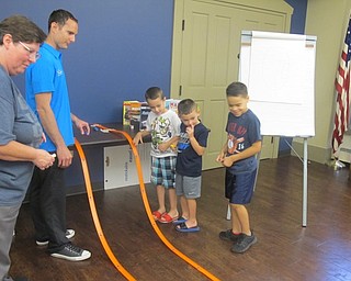 Neighbors | Zack Shively.The library hosted Science Stories with Ryan Martino on Sept. 18. During the event, the children learned about weight distribution on racecars using toy cars and a plastic track. If a car lifted off the track or failed to go striaght on the hardwood floor of the meeting room, Martino and the children taped bolts to the toy cars to make them run better.