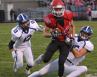 Struthers wide receiver Kevin Caldwell(89) is taken down by Poland defensive back Nathan Alessi(15) and Poland defensive back Brandon Barringer(13) after catching a pass during the first quarter as Poland High School takes on Struthers High School, Friday, Sept. 29, 2017, at Stuthers High School in Struthers. Poland won 33-0...(Nikos Frazier | The Vindicator)..
