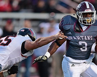 Boardman's Domonhic Jennings runs the football while avoiding the arm tackle from Canfield's Vince Giordano during the first half of their game Friday night at Boardman High School. Canfield won 17-7. DAVID DERMER | THE VINDICATOR