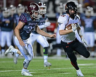 Canfield's Tyler Dobrindt runs away from Boardman's Neil Bevaqua after a reception during the first half of their game Friday night at Boardman High School. Canfield won 17-7. DAVID DERMER | THE VINDICATOR