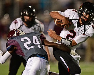 Canfield's Vinny Fiorenza runs through an arm tackle from Boardman's Ceaonne Jones during the first half of their game Friday night at Boardman High School. Canfield won 17-7. DAVID DERMER | THE VINDICATOR