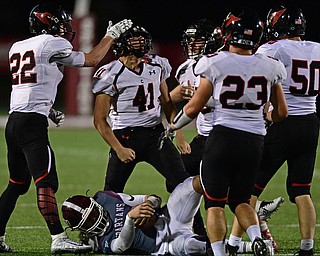 Canfield's Anthony D'Alesio, center, celebrates with Tyler Dobrindt, Vince Giordano, David Crawford and Tyler Stein after sacking Boardman's Mike O'Horo, bottom, during the second half of their game Friday night at Boardman High School. Canfield won 17-7. DAVID DERMER | THE VINDICATOR