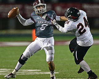 Boardman's Mike O'Horo fights to get the ball off while being grabbed by Canfield's Angelo Petracci during the second half of their game Friday night at Boardman High School. Canfield won 17-7. DAVID DERMER | THE VINDICATOR