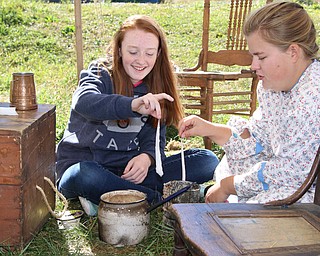 Lauren Johnston (13,left) of Newell, WV makes a dip candle with Kelsey Wormley (right) of Struthers during the Struthers Historical Society's open house on Saturday afternoon.  Dustin Livesay  |   The Vindicator  9/30/17  Struthers