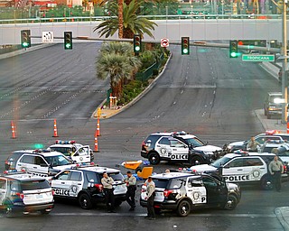 Police vehicles block a street after sunrise Monday, Oct. 2, 2017, in Las Vegas. A mass shooting occurred late night Sunday at a music festival on the Las Vegas Strip. (AP Photo/Ronda Churchill)