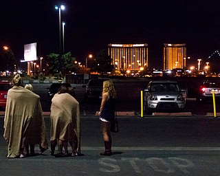 A group of women wait for their ride outside the Thomas & Mack center, which served as a refuge, following a mass shooting at the Route 91 music festival along the Las Vegas Strip, Monday, Oct. 2, 2017, in Las Vegas. (Yasmina Chavez/Las Vegas Sun via AP)