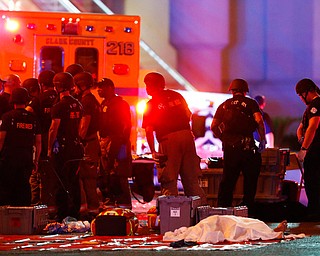 A body is covered with a sheet after a mass shooting in which dozens were killed at a music festival on the Las Vegas Strip on Sunday, Oct. 1, 2017. (Steve Marcus/Las Vegas Sun via AP)