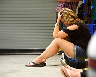 A young woman hides inside the Sands Corporation plane hangar after a gunman opened fire at the Route 91 Harvest Festival on Sunday, Oct. 1, 2017, in Las Vegas. (Photo by Al Powers/Powers Imagery/AP)