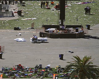 People drive a cart through the scene of a mass shooting at a music festival on the Las Vegas Strip, Monday, Oct. 2, 2017, in Las Vegas. (AP Photo/John Locher)