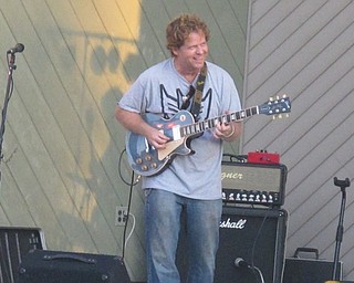 Neighbors | Zack Shively  .Tom Shaffer of Soundbite smiling while playing a solo during Stevie Ray Vaughn's "Pride and Joy" at Austintown's Concert in the Park on Aug. 22. Shaffer played guitar with the band well despite being a new member of the band.