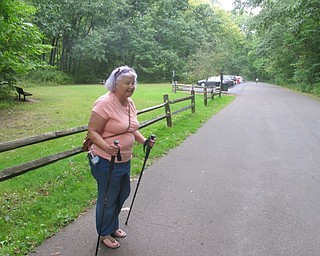 Neighbors | Zack Shively  .Dr. Nicole Mullins lent out her walking poles to a walker who wanted to see if they helped her relieve some pain while walking during "Let’s Move! A Walk for Those with Mobility Challenges" at the East Golf Hike Bike Trail on Aug. 31.