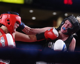 Collen Davis(black) receives a left hook from Jessica Palmieri(red), Thursday, Oct. 5, 2017, at the Covelli Centre in Youngstown. Palmieri won after three rounds by points...(Nikos Frazier | The Vindicator)..