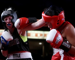 Collen Davis(black) receives a left hook from Jessica Palmieri(red), Thursday, Oct. 5, 2017, at the Covelli Centre in Youngstown. Palmieri won after three rounds by points...(Nikos Frazier | The Vindicator)..