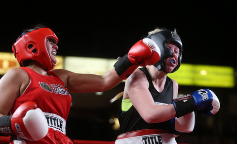 Collen Davis(black) receives a left hook from Jessica Palmieri(red), Thursday, Oct. 5, 2017, at the Covelli Centre in Youngstown. Palmieri won after three rounds by points...(Nikos Frazier | The Vindicator)..