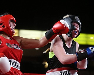 Collen Davis(black) receives a left hook from Jessica Palmieri(red), Thursday, Oct. 5, 2017, at the Covelli Centre in Youngstown. Palmieri won after three rounds by points...(Nikos Frazier | The Vindicator)..