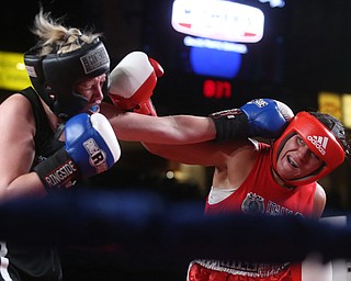 Collen Davis(black) receives a right hook from Jessica Palmieri(red), Thursday, Oct. 5, 2017, at the Covelli Centre in Youngstown. Palmieri won after three rounds by points...(Nikos Frazier | The Vindicator)..