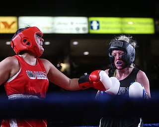 Jessica Palmieri(red) connects with Collen Davis(black), Thursday, Oct. 5, 2017, at the Covelli Centre in Youngstown. Palmieri won after three rounds by points...(Nikos Frazier | The Vindicator)..