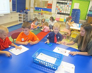 Neighbors | Zack Shively.Big Dog Emily Ziegler helped kindergarten students with their schoolwork at Poland Union Elementary on Sept. 26. Pictured, from left to right, are kindergarteners Landon McDougal, Ryan Metzinger, Ian Hardman and senior Emily Ziegler.