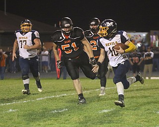             ROBERT  K. YOSAY | THE VINDICATOR..McDonald at Mineral Ridge..#10 McDonald Josh Celli breaks around end  for a first down pursueing him is  #51 Mineral Ridge Troy Squiric and 24 Michael McLean second quarter action