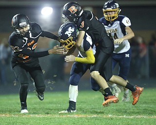             ROBERT  K. YOSAY | THE VINDICATOR..McDonald at Mineral Ridge.#10 McDonald Josh Celli carries a player for a first down during third quarter action..josh is carrying #3 Randall Miller as #23 Nathan Spalding gets in the action behind them isMcDonald #44Zach Gray