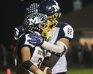             ROBERT  K. YOSAY | THE VINDICATOR..McDonald at Mineral Ridge.McDonald #31 Alex Cintron is congratulated as he scored in the third quarter by team mates 62 Ali Hammond and 61 (hidden) David Beraducci.making the score 41-0