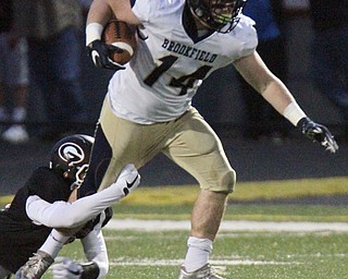 William D. Lewis The Vindicator Brookfield's Alex Clark(14) drags Girard'sAidan Warga along for yardage during 1rst half action 0-6-17 in Girard.