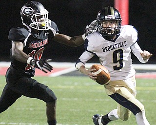 William D. Lewis The VindicatorGirard's Jamil Bannister(0) persues Brookfield QB Haden Gibson(9)during 10-6-17 action at Girard.