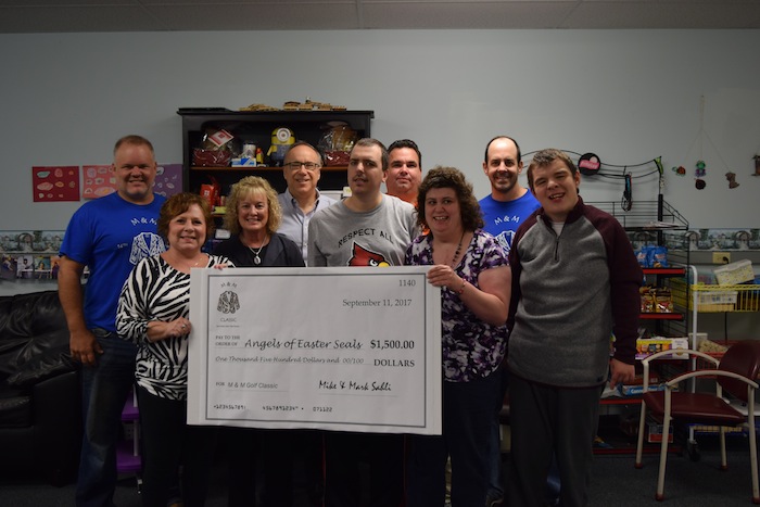 Mike and Mark Sahli presented a check recently for $1,500 from the 19th annual M & M Golf Classic to the Angels of Easter Seals. The tournament took place Sept. 3 at Mill Creek Park golf course. The Sahli brothers founded the M & M Golf Classic to benefit local charities throughout the Mahoning Valley. Clients of the Easter Seals skill-development program will benefit from this year’s donation. For more information about Easter Seals, call 330-743-1168 or visit www.mtc.easterseals.com. Above, from left, are Mike Sahli; Gerogeann Buonpane, president of the Angels of Easter Seals; Lynn Sahli, former president of the Angels of Easter Seals; Tim Nelson, Easter Seals president and CEO; Joey Serich, skill development client; Dan Sefcik, skill development assistant; Danielle Madden, skill development client; Mark Sahli, and David Rosko, skill development client.
