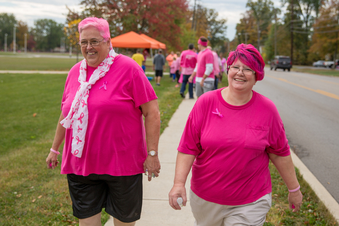 Sherrie Baun (left) and  Cheri Foor of Salem walk with stride during the breast cancer awareness walk at Austintown Fitch High School on Saturday.