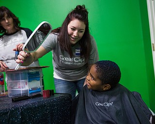 Kristian, 6 of Austintown checks out his painted blue hair spray-painted by Stephanie Merrell at the Great Clips table during Skate Zone's first Community Day event on Saturday.