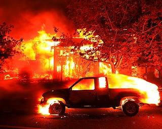 Coffey Park homes burn early Monday Oct. 9, 2017 in Santa Rosa, Calif. More than a dozen wildfires whipped by powerful winds been burning though California wine country. The flames have destroyed at least 1,500 homes and businesses and sent thousands of people fleeing. (Kent Porter/The Press Democrat via AP)