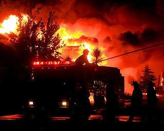Gold Fidge firefighters use a deck gun to protect structures in Coffey Park in Santa Rosa, Calif., Monday Oct. 9, 2017. More than a dozen wildfires whipped by powerful winds been burning though California wine country. The flames have destroyed at least 1,500 homes and businesses and sent thousands of people fleeing. (Kent Porter/The Press Democrat via AP)