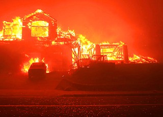A home burns in Fountaingrove, Monday Oct. 9, 2017 in Santa Rosa, Calif. More than a dozen wildfires whipped by powerful winds been burning though California wine country. The flames have destroyed at least 1,500 homes and businesses and sent thousands of people fleeing. (Kent Porter/The Press Democrat via AP)